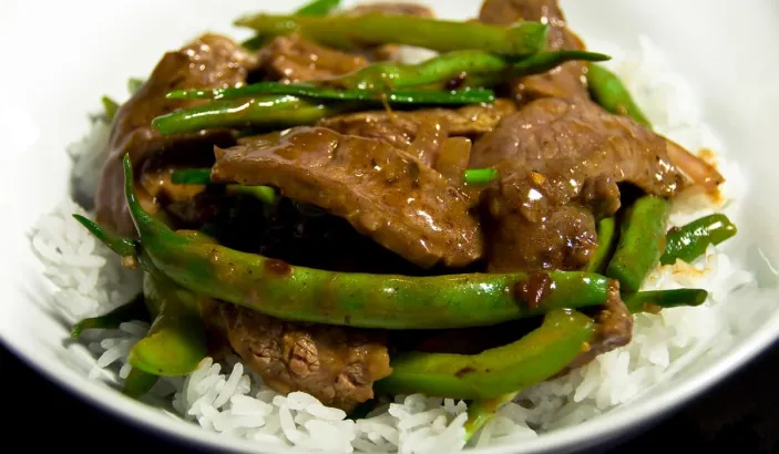 Dish made with rice, green beans, and meat in sauce