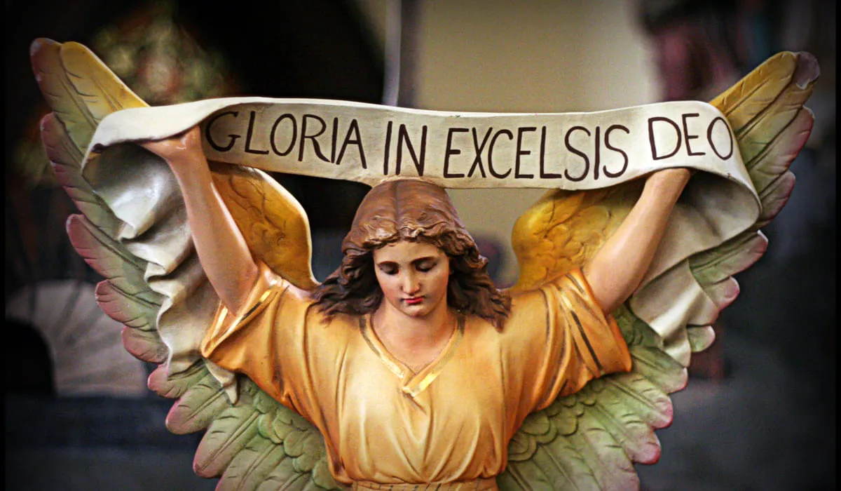 Statuette qui tient un bandeau écrit Gloria in excelsis deo